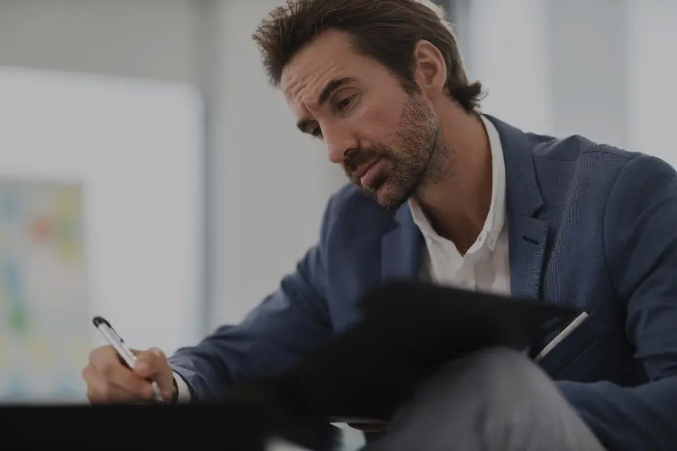 Operations manager working through a stack of paper documents at his desk