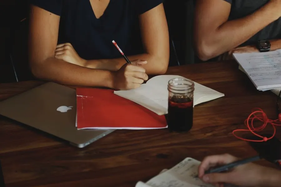 Close-up of a team working through documents and laptops around a table